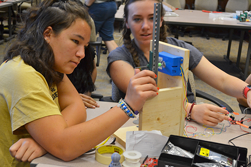 Julia Tung (left) works on her team's 3D printer.